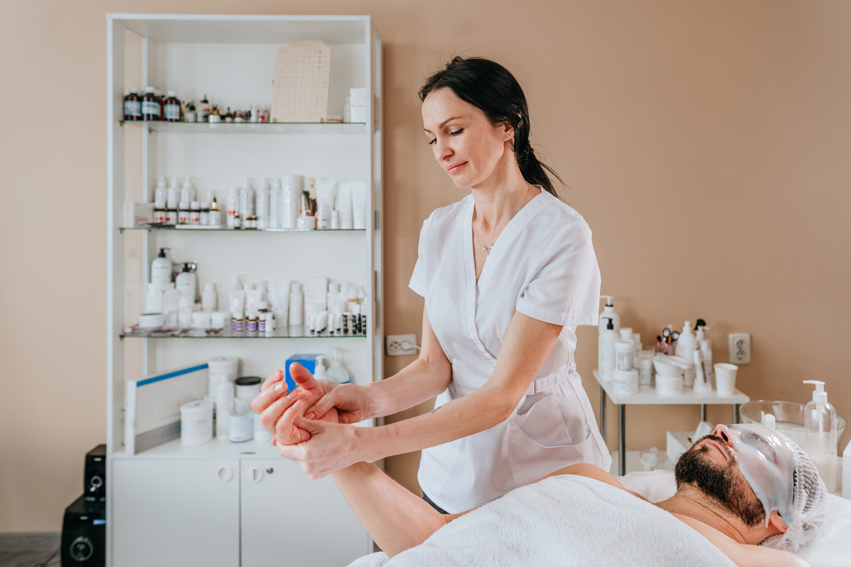 Esthetician or facialist gives a relaxing massage to a man